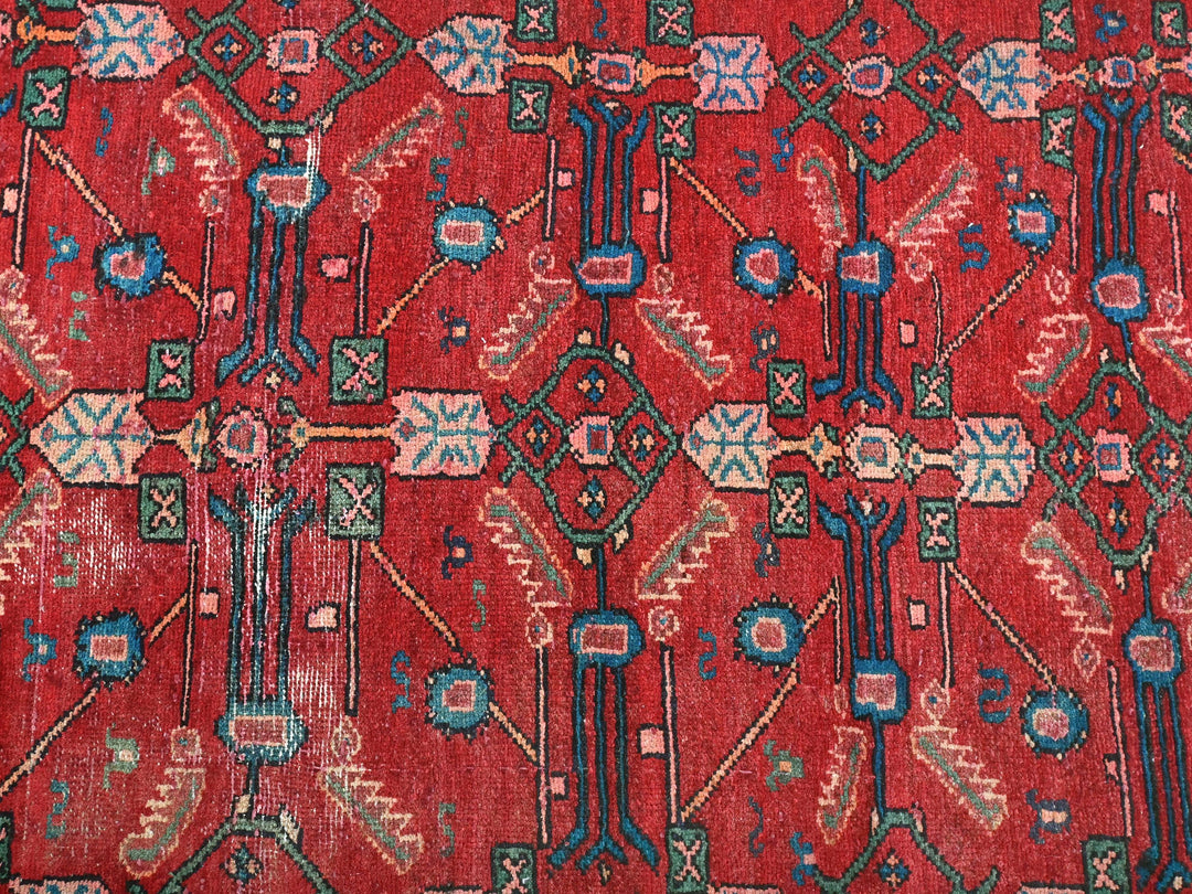 a close up of a red rug with blue and green designs