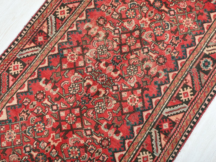 a red and black oriental rug on a white floor