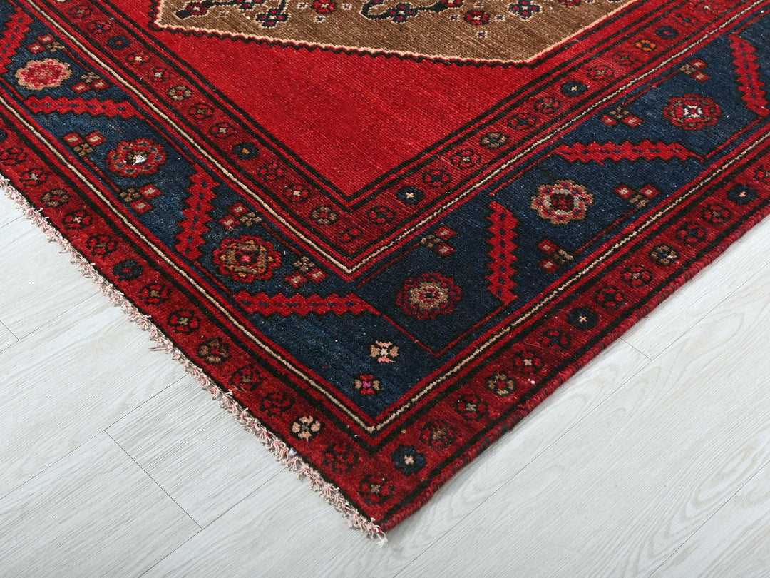 a red rug with a gold border on a white floor