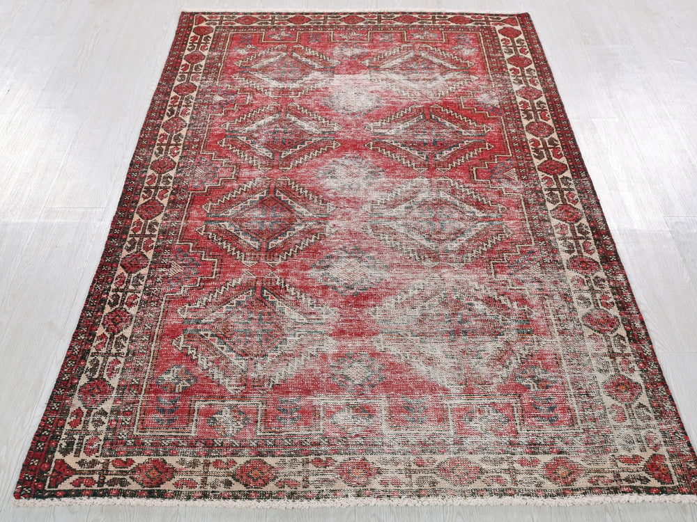 a red and beige rug on a white floor