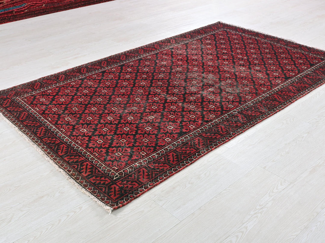 a red and black rug on a white floor