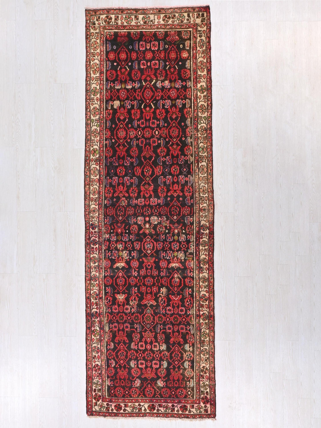 a red and black rug hanging on a wall