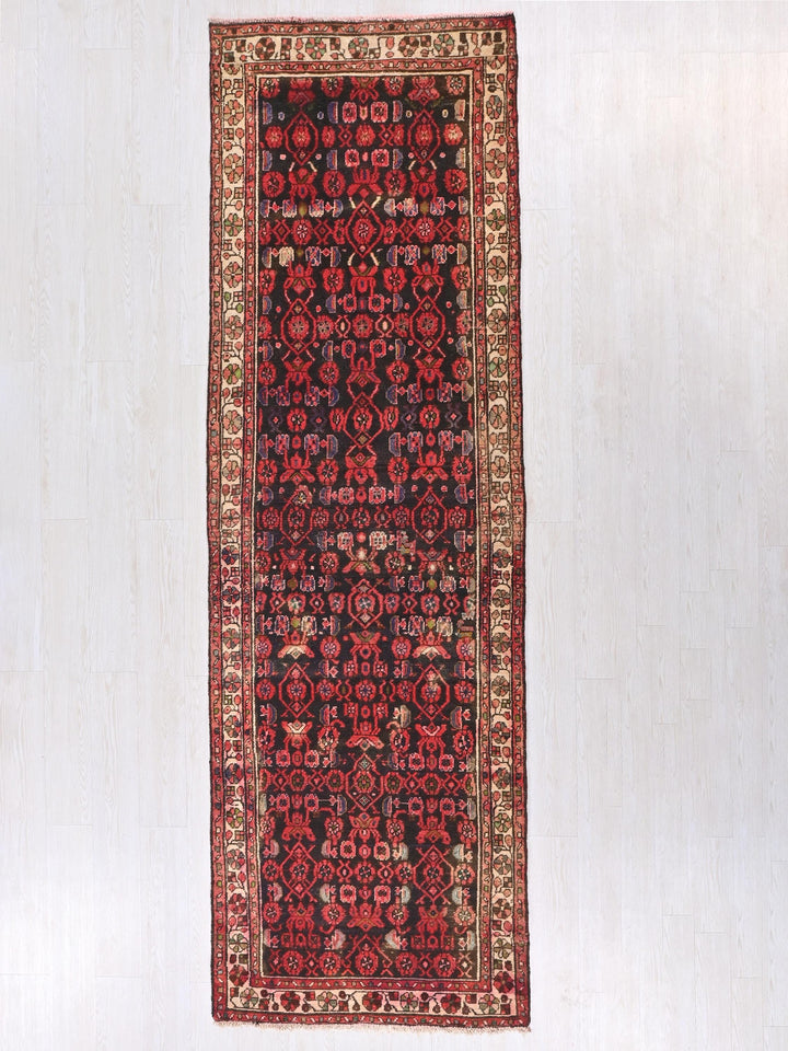 a red and black rug hanging on a wall