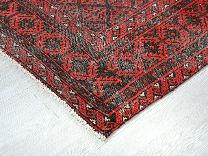 a red and black rug on a white floor
