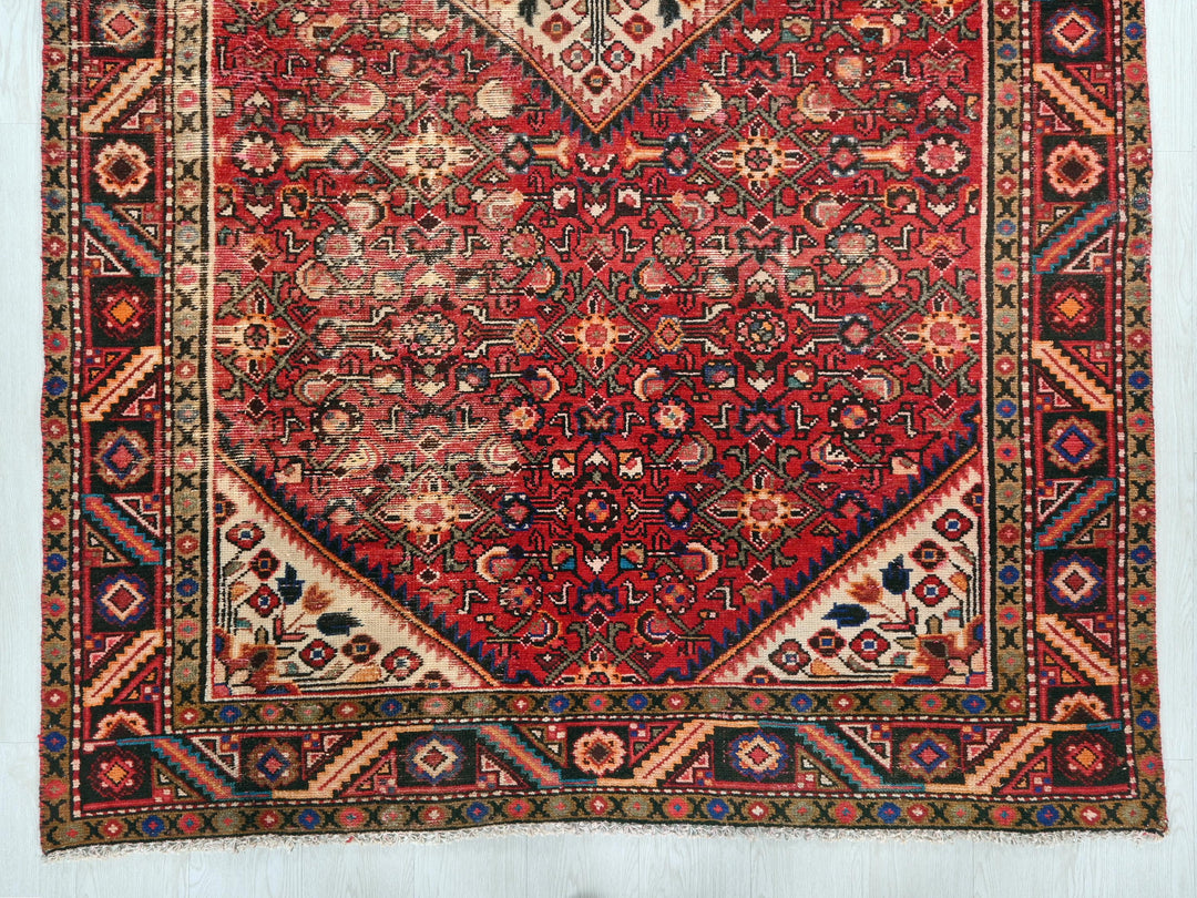a red rug with a diamond shaped design