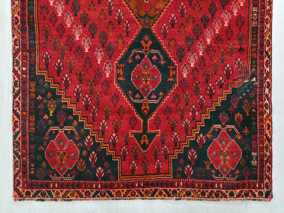 a red and black oriental rug hanging on a wall
