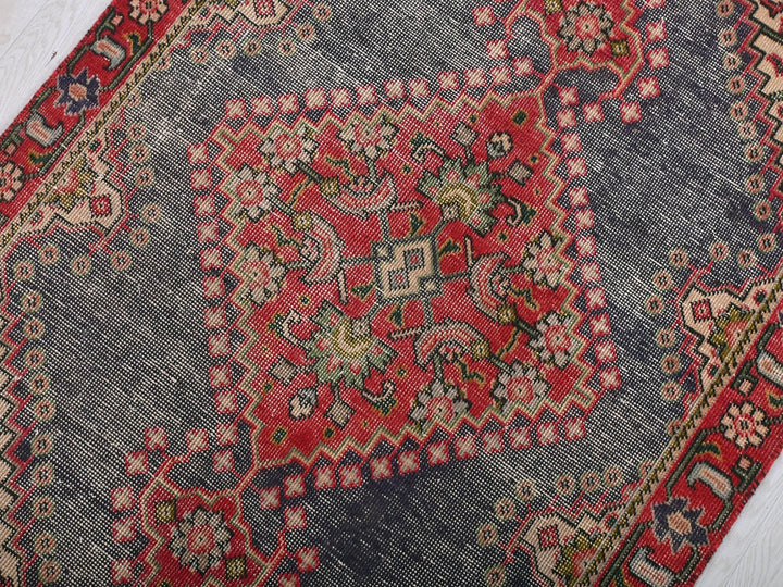 a red and blue oriental rug on a white floor