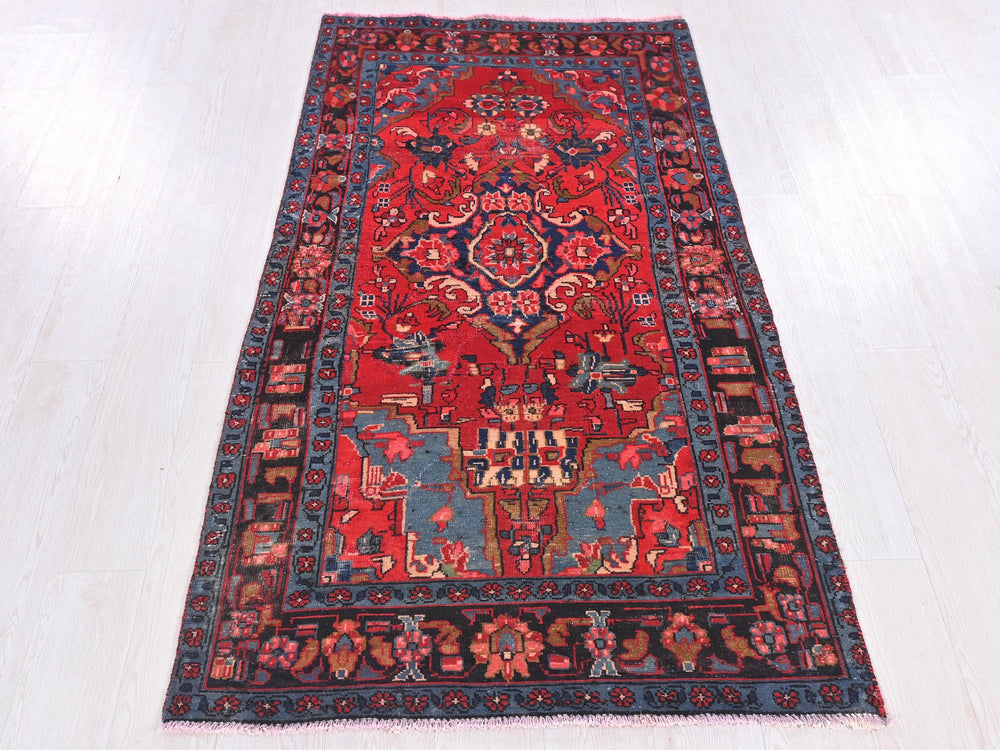 a red and blue rug on a white floor
