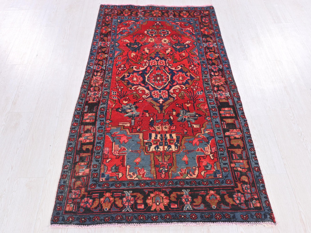 a red and blue rug on a white floor