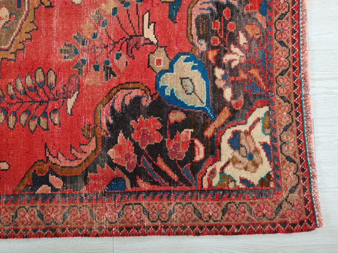a red rug with a floral design on it