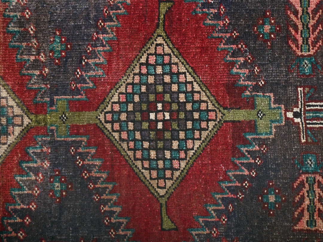 a red and blue rug with a design on it