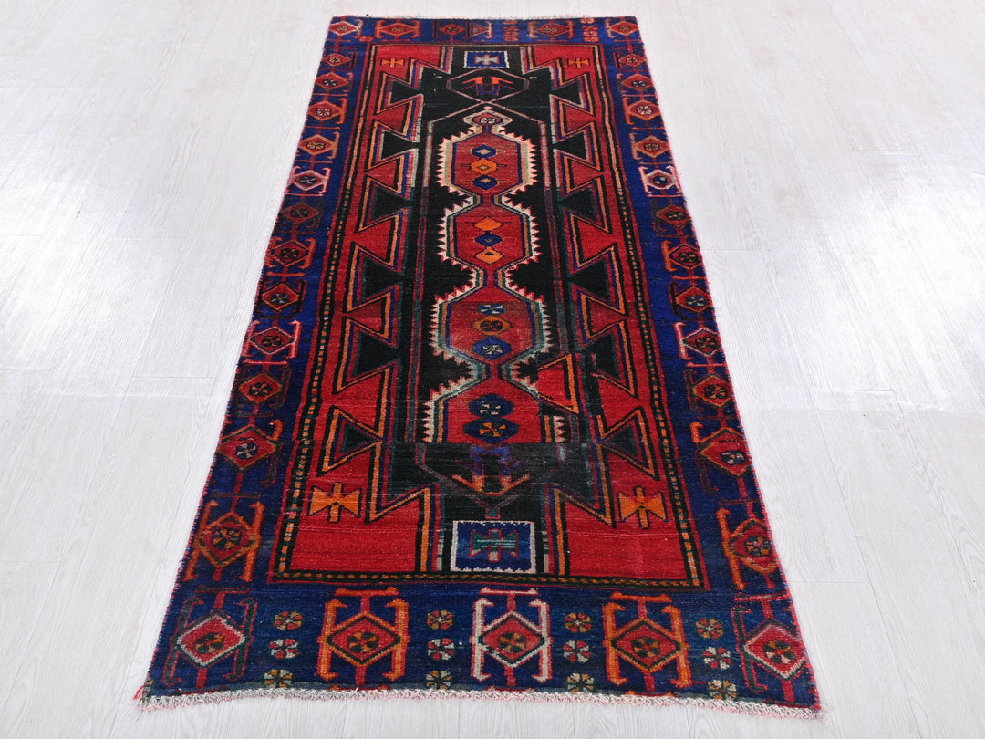 a red and blue rug on a white floor