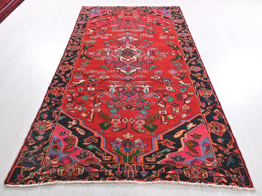 a red rug with a black border on a white floor