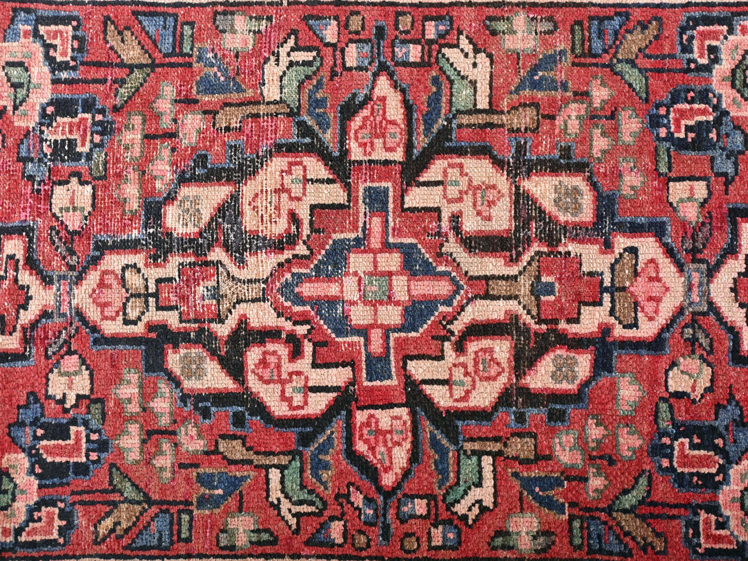 a red rug with a floral design on it