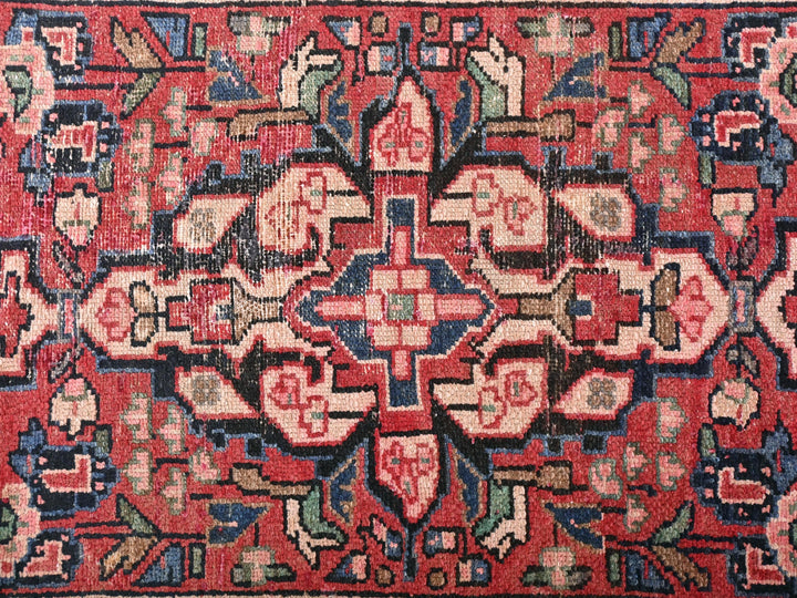 a red rug with a floral design on it