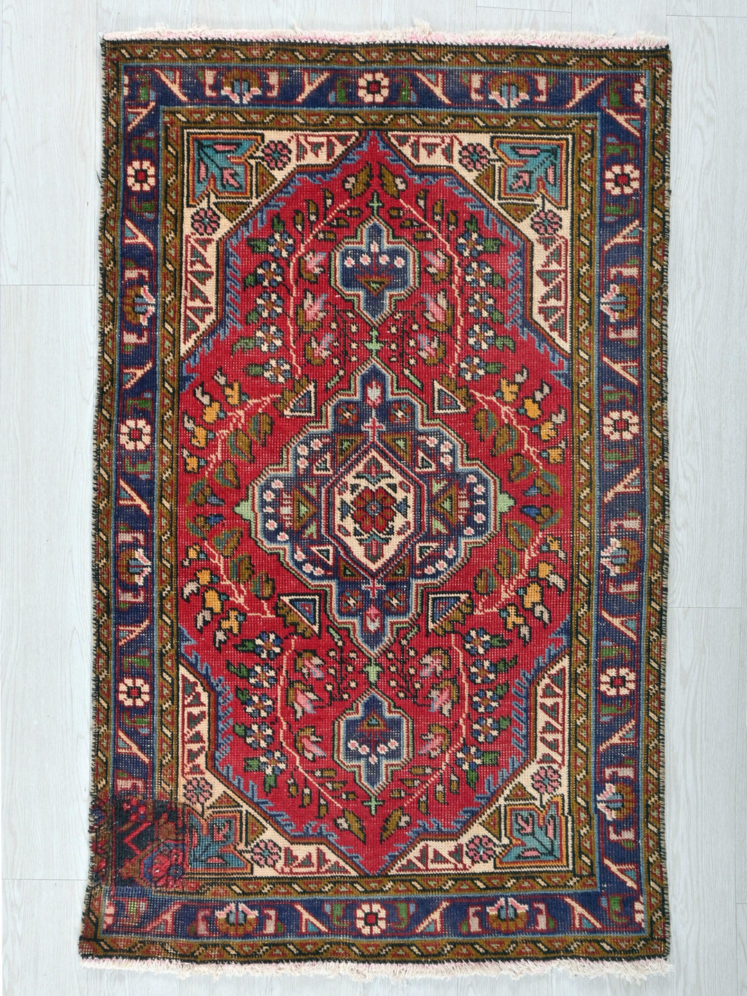 a red rug with a blue and yellow design on it