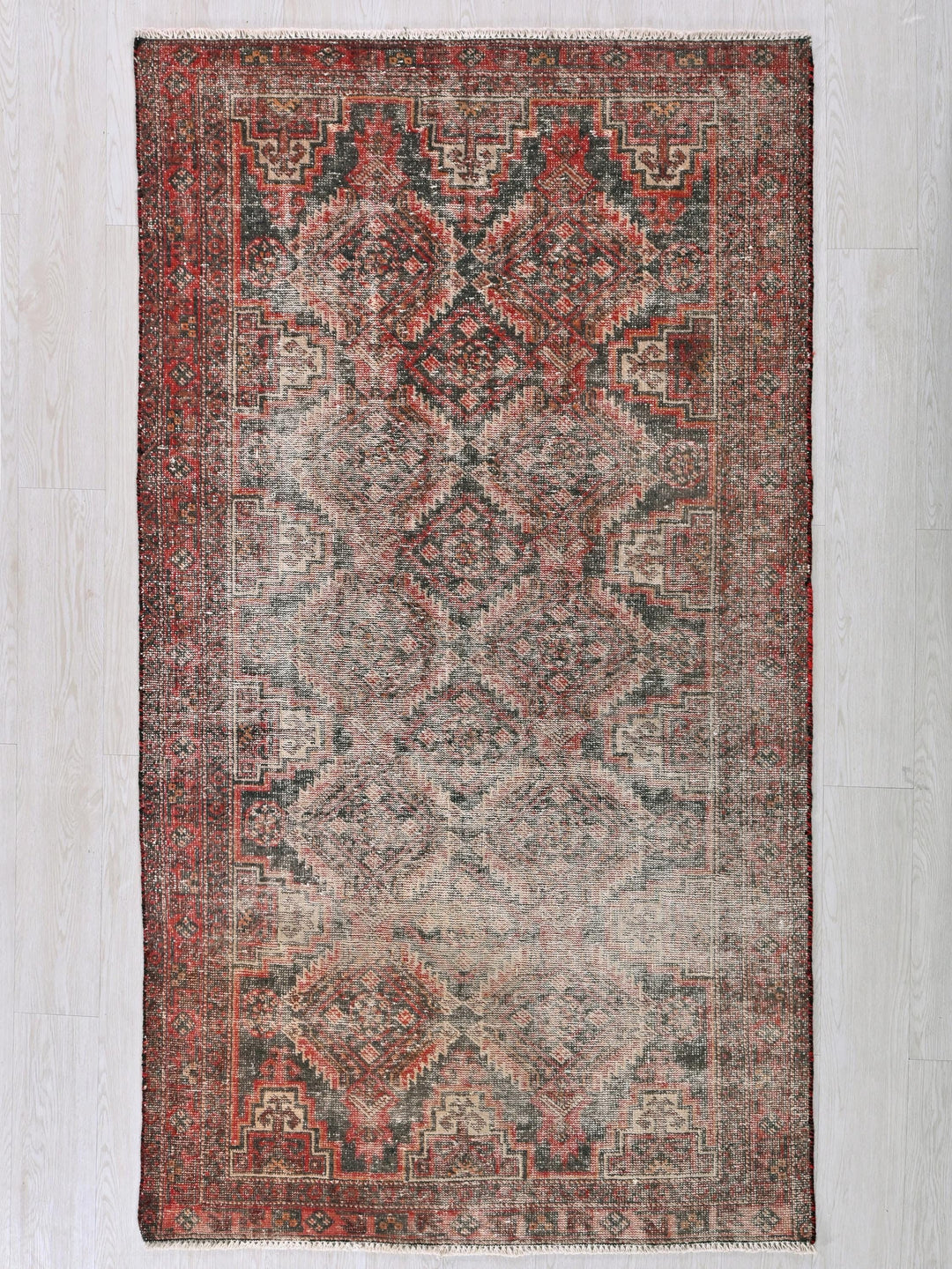 a red and blue rug on a white wall