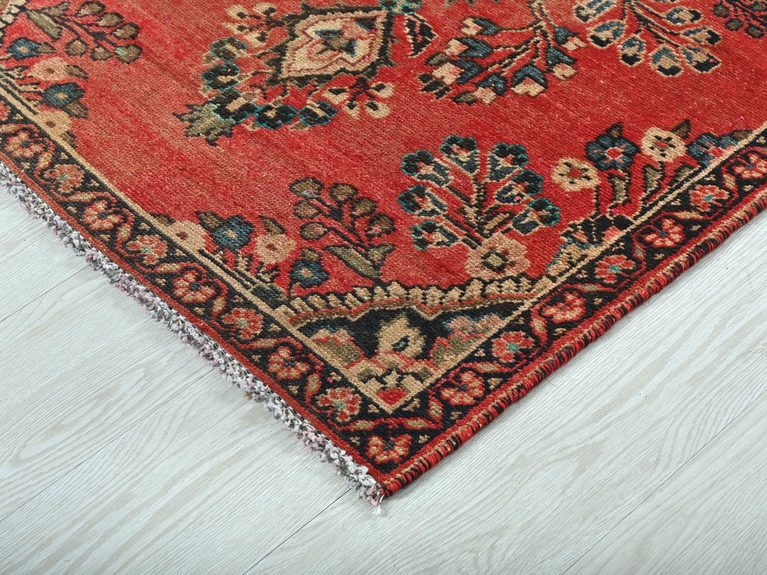 a red rug on a white wooden floor