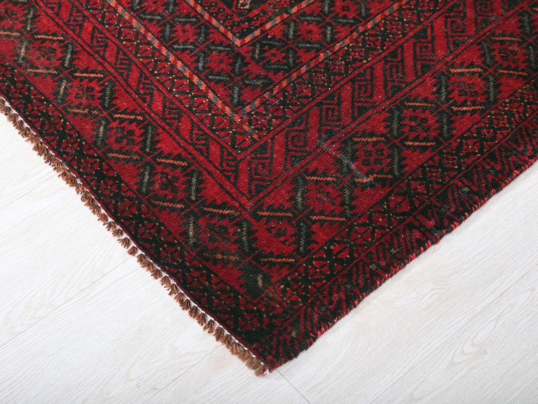 a close up of a red rug on a white floor