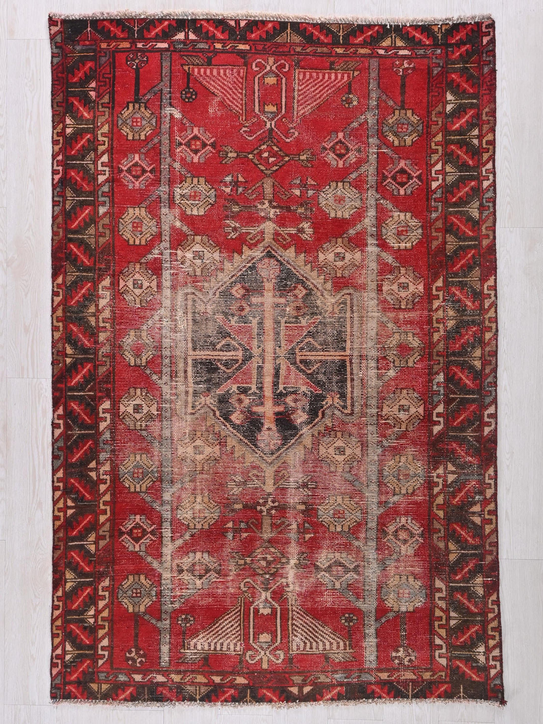 a red rug with a design on the middle of it