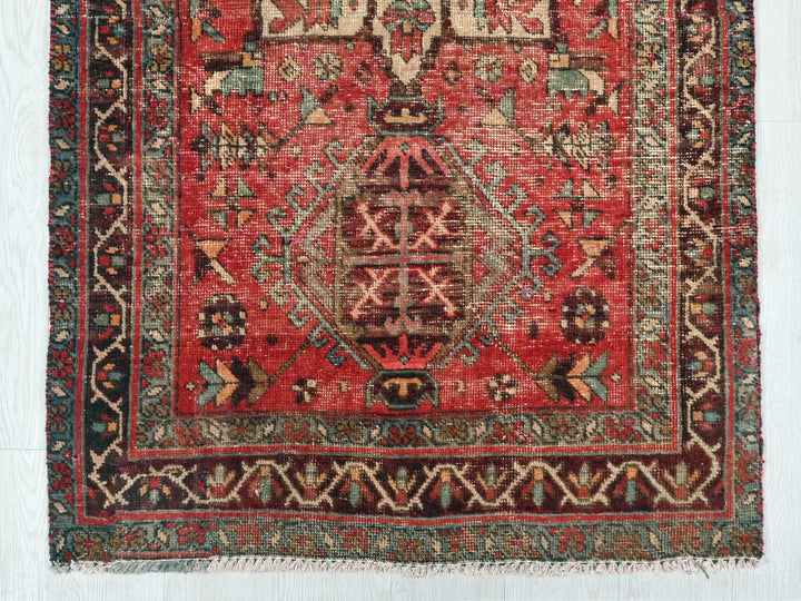 a red rug with a design on the middle of it