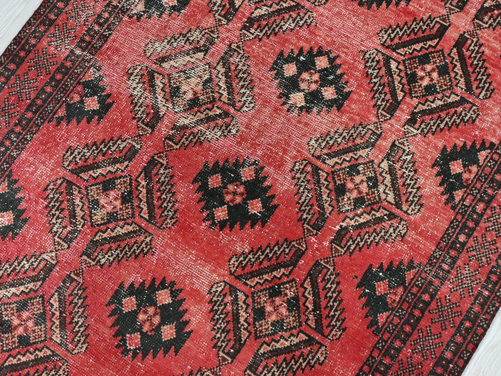 a red rug with black and white designs on it