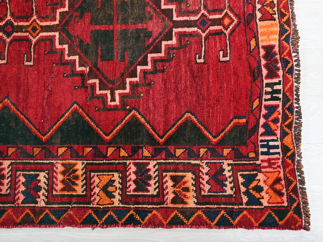 a red rug with a design on it