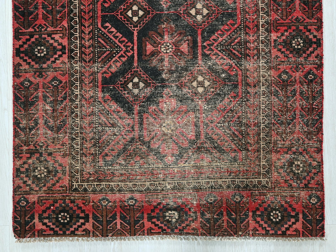 a red and black oriental rug on a white background