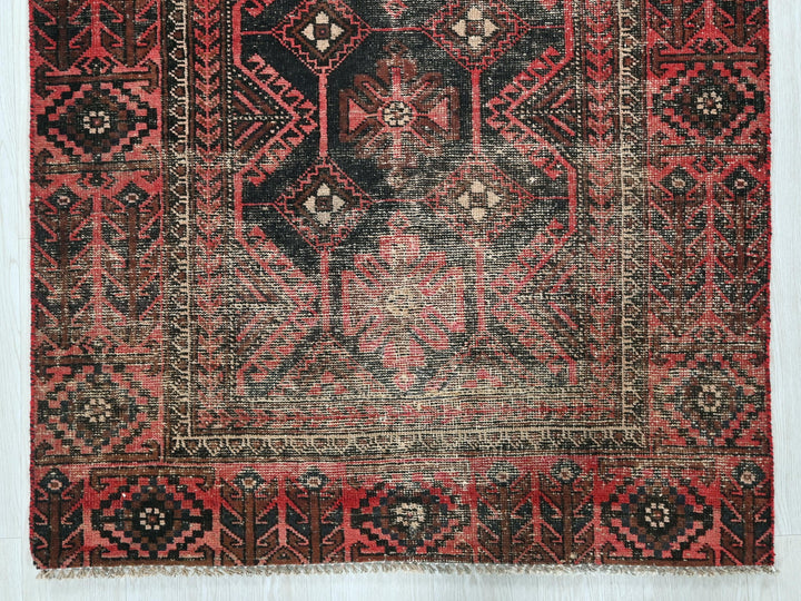 a red and black oriental rug on a white background
