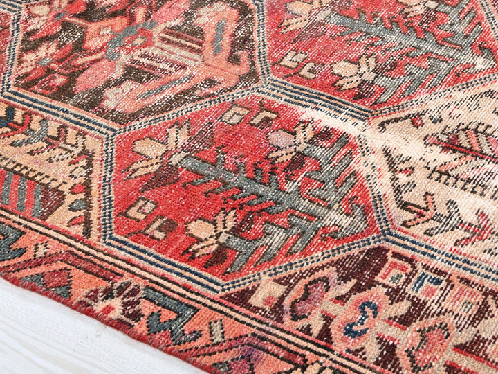 a red and blue oriental rug on a wooden floor