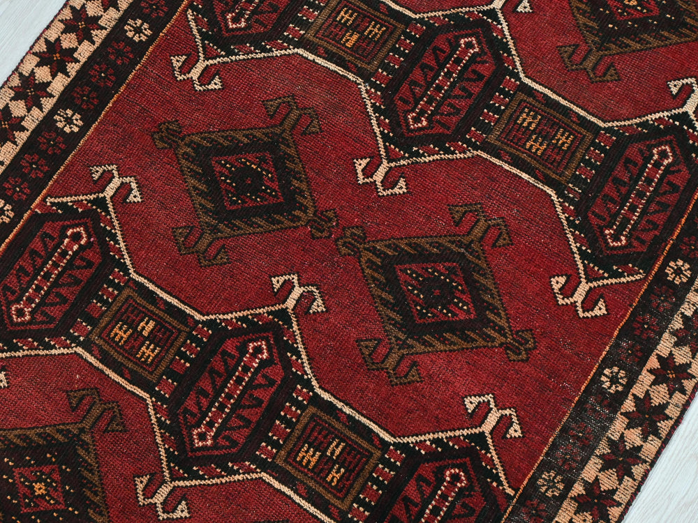 a red rug with a pattern on the middle of it