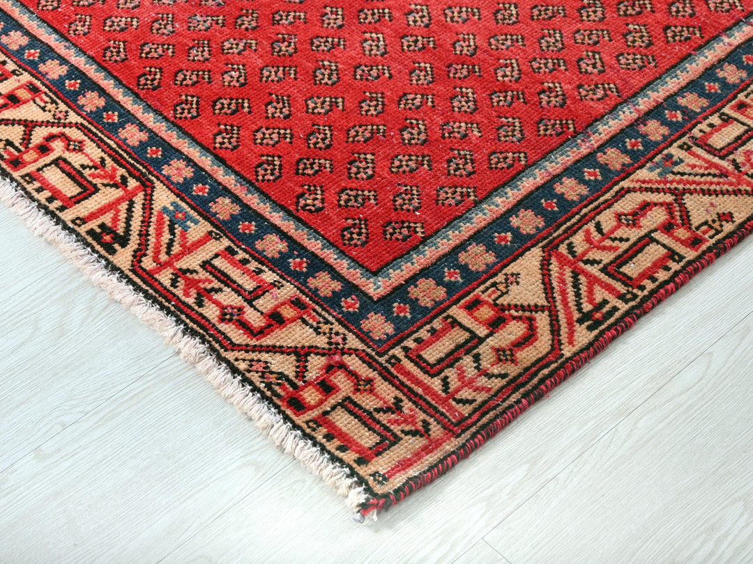 a red rug on a white wooden floor
