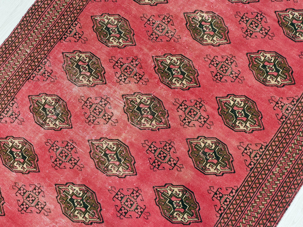 a close up of a red rug on a white floor