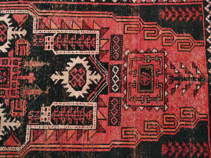 a red rug with a black and white design on it