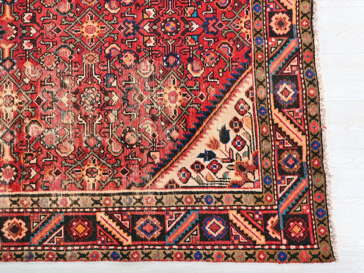 a red rug with a triangle shaped design on it