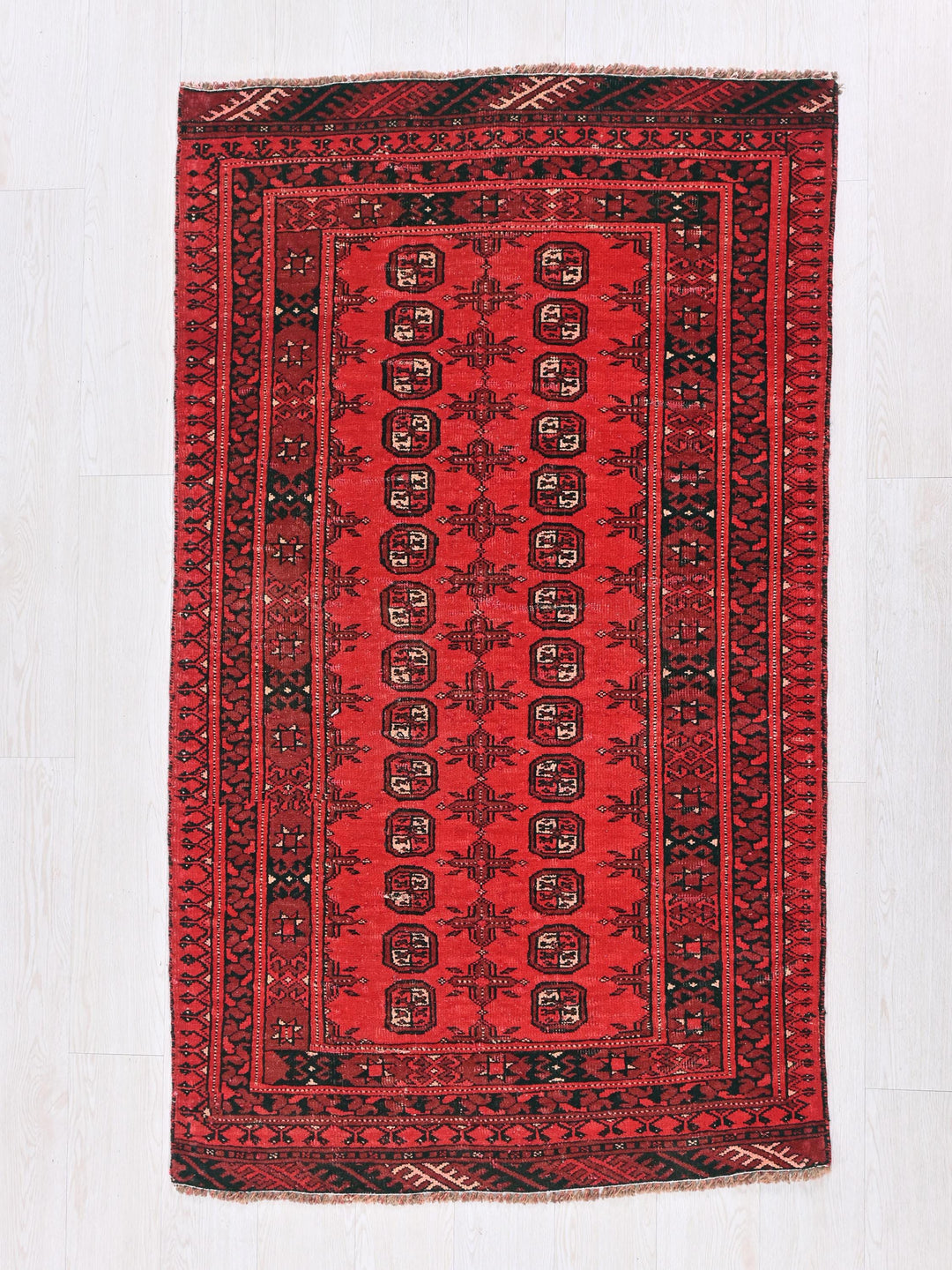 a red rug on a white wooden floor