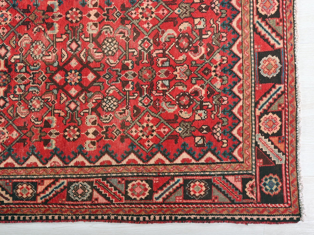 a red and black rug with a design on it