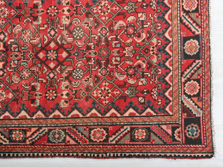 a red and black rug with a design on it