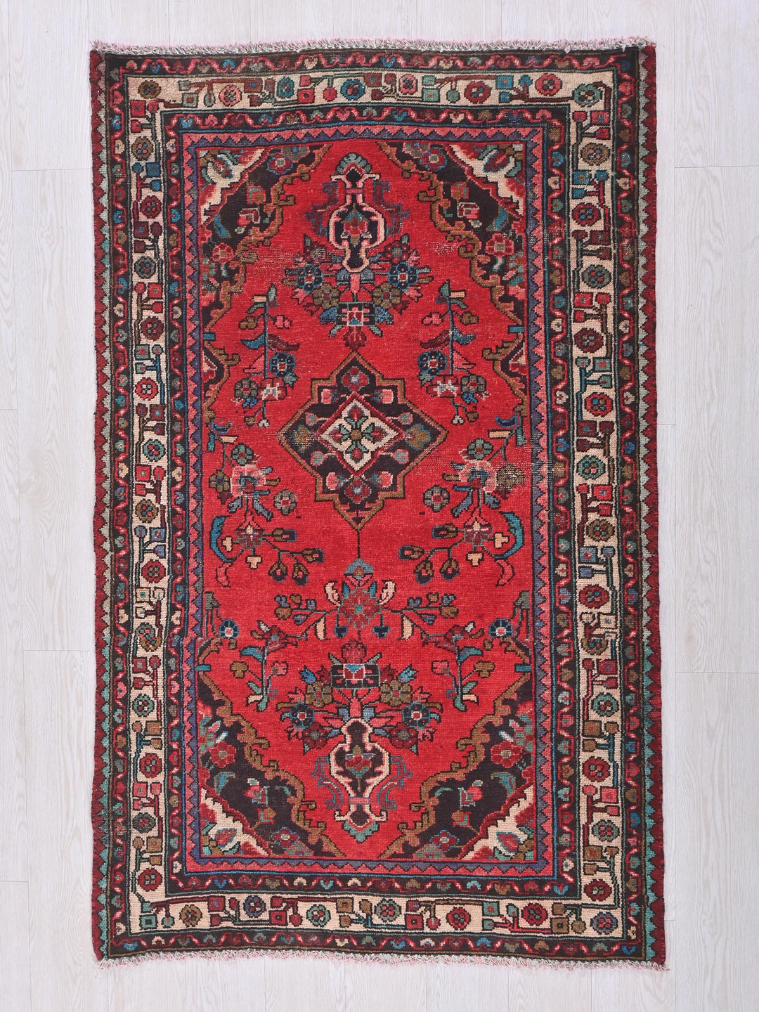 a red rug on a white wooden floor