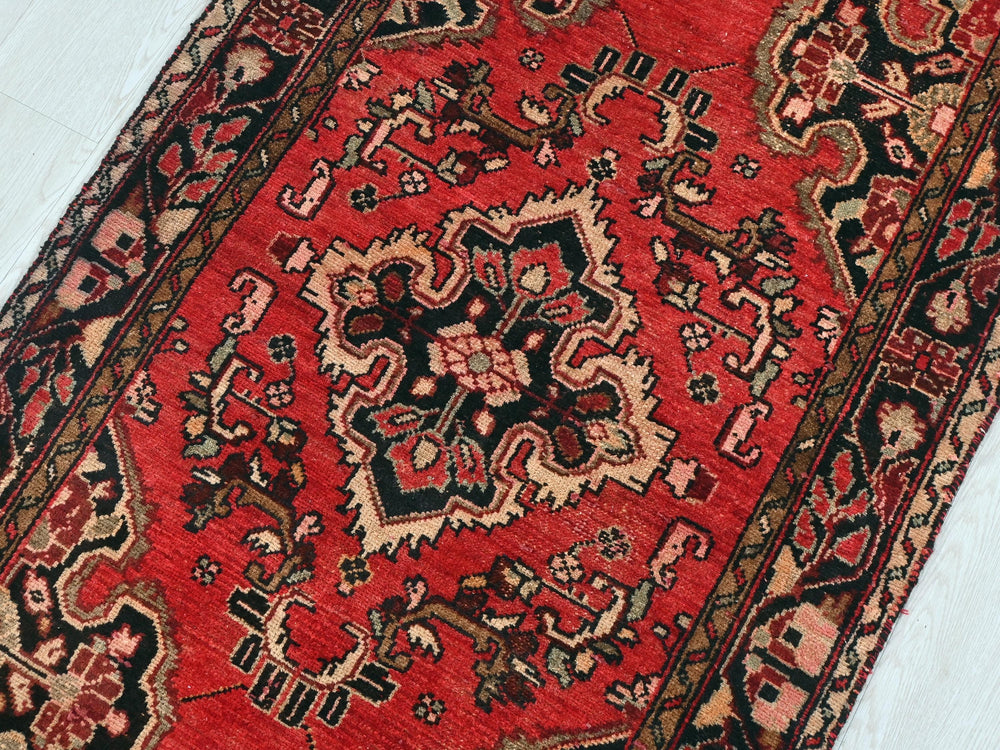 a red oriental rug on a white floor