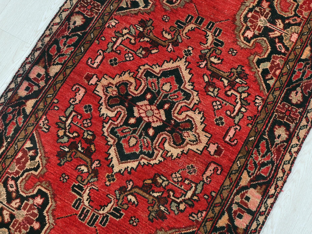 a red oriental rug on a white floor