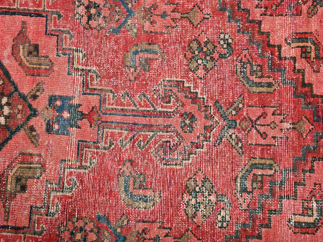 a red rug with a pattern on it