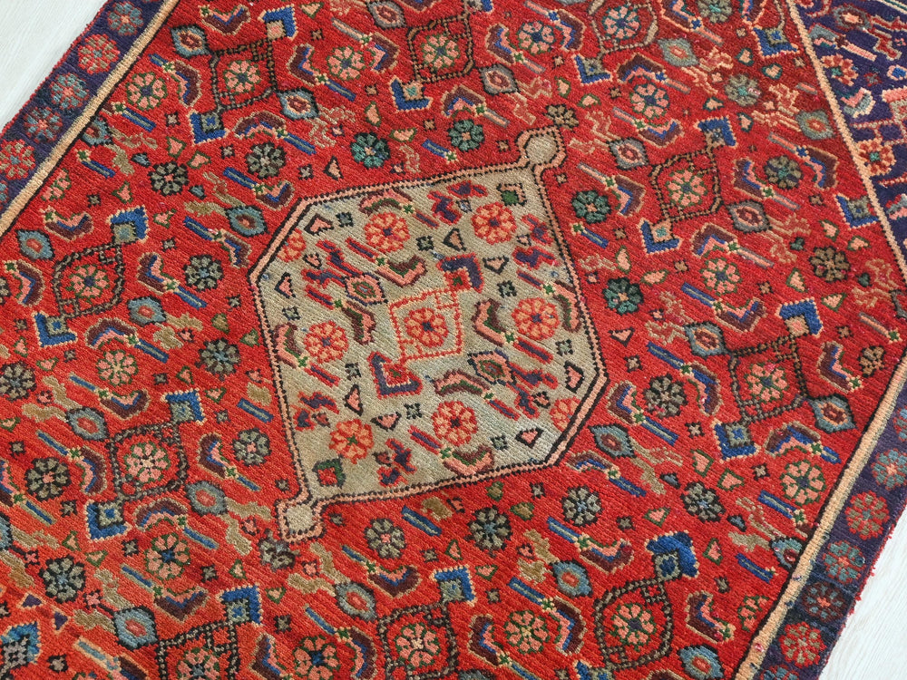 a red oriental rug with a blue border