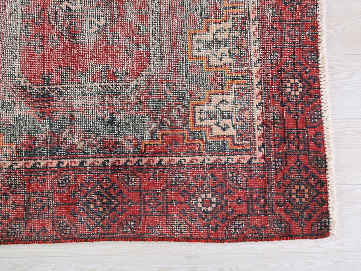 a red and black rug on a wooden floor