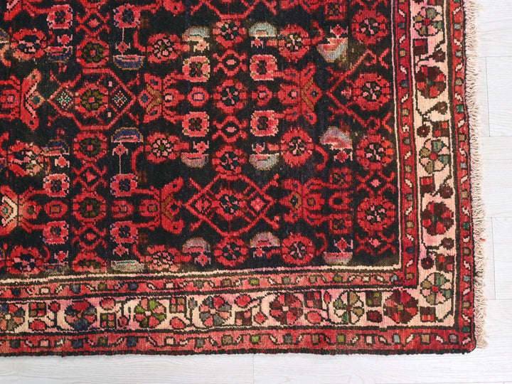 a red and black rug on a white floor