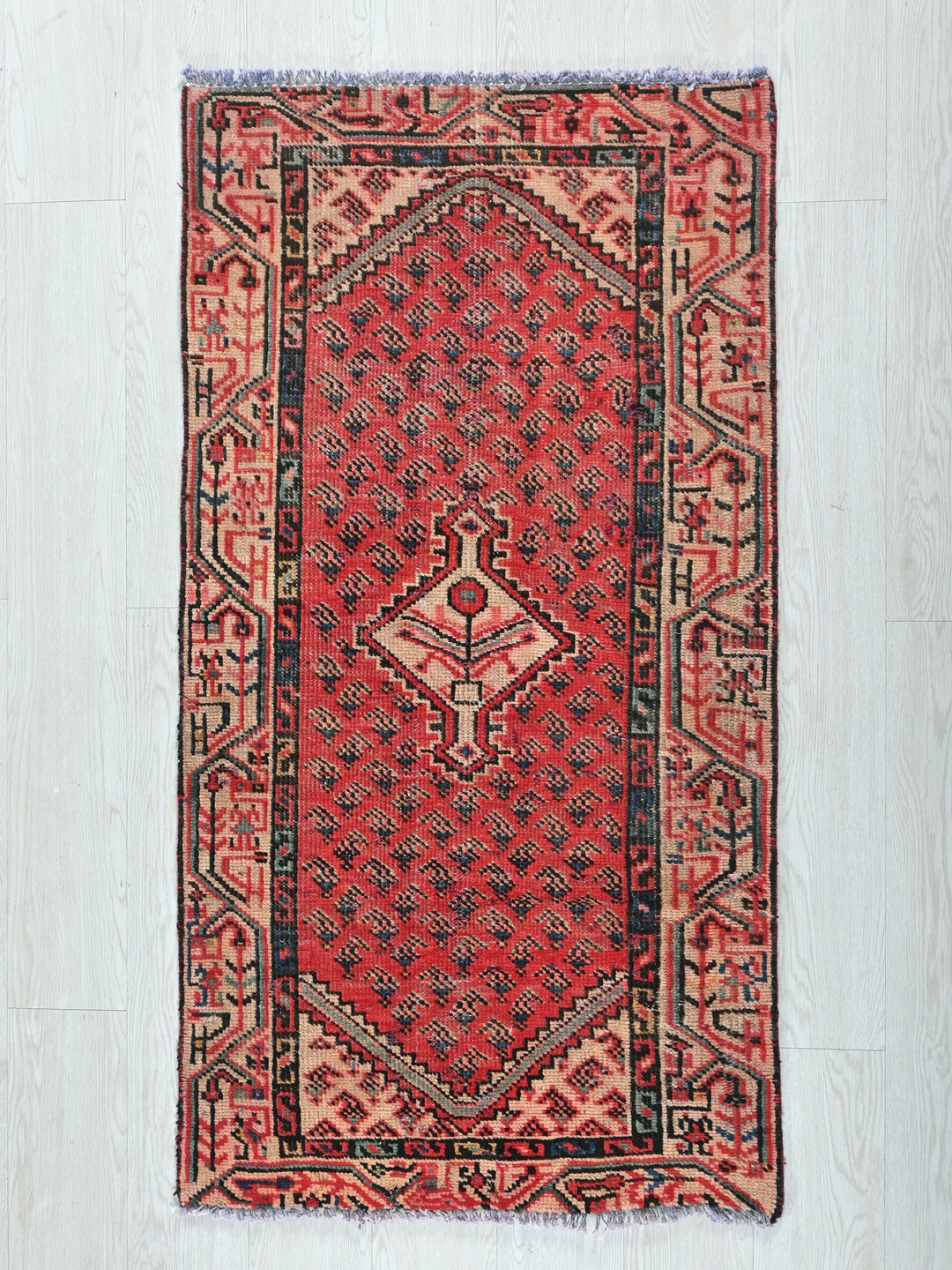 a red rug on a white wooden floor
