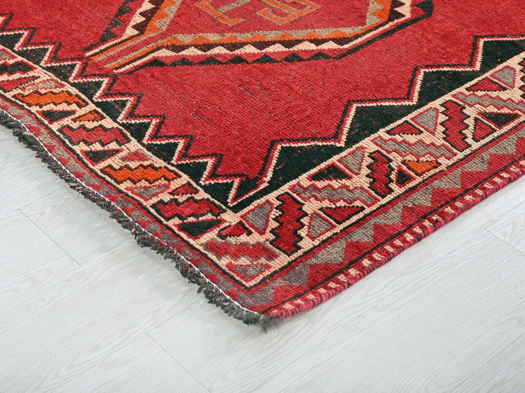 a red and black rug on a white floor