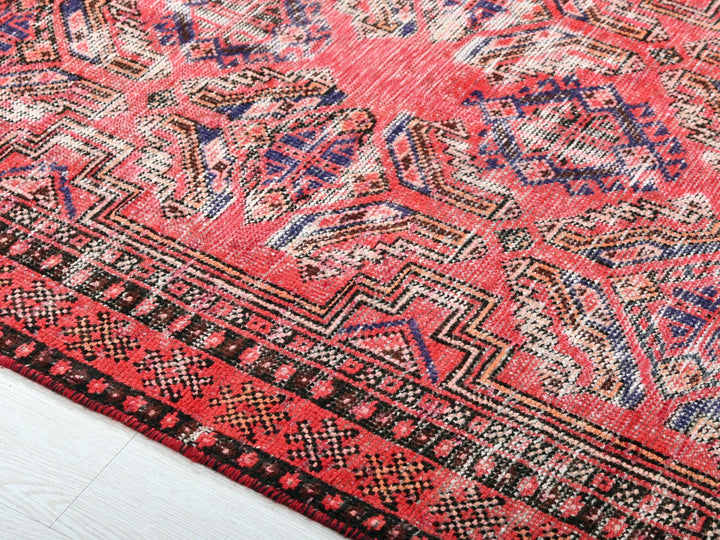 a close up of a red rug on a white floor
