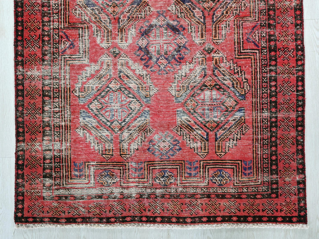 a red and black rug with a design on it