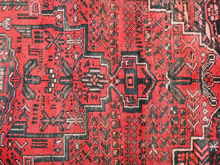 a close up of a red and black oriental rug